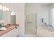 Bright bathroom featuring a glass-enclosed shower, soaking tub, and vanity with ample countertop space at 3964 Silk Oak Ln, Palm Harbor, FL 34685