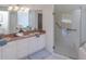Bathroom with double sink vanity, glass shower, and neutral tile flooring for a clean, modern aesthetic at 3964 Silk Oak Ln, Palm Harbor, FL 34685