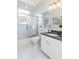 Bathroom showcasing a granite countertop, modern fixtures, and tiled shower area with a glass door at 3964 Silk Oak Ln, Palm Harbor, FL 34685
