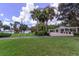 Well-manicured community area with an American flag, lake views, and a pergola-covered seating area at 3964 Silk Oak Ln, Palm Harbor, FL 34685