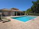 Relaxing community pool with lounge chairs and a covered patio area for residents to enjoy at 3964 Silk Oak Ln, Palm Harbor, FL 34685