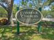 Lansbrook Commons community sign displaying the address and resident-only designation amidst green grass and trees at 3964 Silk Oak Ln, Palm Harbor, FL 34685