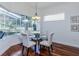 Bright dining area featuring a chandelier, hardwood floors, and large windows with natural light at 3964 Silk Oak Ln, Palm Harbor, FL 34685