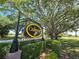 Charming Oakmont entrance sign nestled among trees, manicured shrubs, and a lush green lawn at 3964 Silk Oak Ln, Palm Harbor, FL 34685