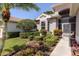 Front exterior view of the home showcasing manicured shrubs, a walkway, and a well-kept lawn at 3964 Silk Oak Ln, Palm Harbor, FL 34685