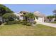 Charming single-story home with a well-manicured lawn, mature trees, and a two-car garage at 3964 Silk Oak Ln, Palm Harbor, FL 34685