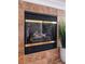 Close up of a living room fireplace surrounded by decorative tile and featuring a glass enclosure at 3964 Silk Oak Ln, Palm Harbor, FL 34685