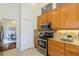 Modern kitchen features wooden cabinetry, granite countertops, and stainless steel appliances at 3964 Silk Oak Ln, Palm Harbor, FL 34685