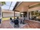 Screened lanai with tile flooring, outdoor seating, and views of the backyard at 3964 Silk Oak Ln, Palm Harbor, FL 34685