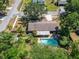 An aerial shot shows the house with a backyard oasis, lush greenery, and a sparkling private pool at 402 Merlin Ct, Brandon, FL 33510