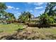 Spacious backyard with mature landscaping, including palm trees and garden beds, perfect for outdoor living and entertaining at 402 Merlin Ct, Brandon, FL 33510