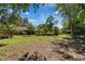 Lush backyard with mature trees, palm trees, and garden beds surrounding a hot tub area, perfect for outdoor living at 402 Merlin Ct, Brandon, FL 33510