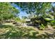 Lush backyard with mature trees and plantings surrounding a pool and patio area, offering privacy and tranquility at 402 Merlin Ct, Brandon, FL 33510