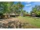 Expansive backyard featuring a well-maintained lawn, mature trees, and a hot tub area, ideal for relaxation and recreation at 402 Merlin Ct, Brandon, FL 33510