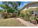 Fenced backyard featuring lush plantings and a brick path along side of the house at 402 Merlin Ct, Brandon, FL 33510