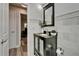 Modern bathroom with marble tile, a sleek black vanity, and wood look floors in adjacent area at 402 Merlin Ct, Brandon, FL 33510