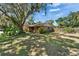 Landscaped front yard with mature tree shading this charming brick home at 402 Merlin Ct, Brandon, FL 33510