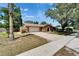 Brick home featuring an arched doorway, two-car garage, and a spacious driveway at 402 Merlin Ct, Brandon, FL 33510