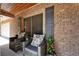 Relaxing front porch featuring patio furniture, blue shutters and a beautiful brick facade at 402 Merlin Ct, Brandon, FL 33510