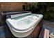 Close-up of a pristine hot tub with bubbling water, surrounded by a brick wall and lush tropical landscaping at 402 Merlin Ct, Brandon, FL 33510