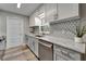 Modern kitchen with grey cabinets, granite countertops, stainless steel appliances, and stylish backsplash at 402 Merlin Ct, Brandon, FL 33510
