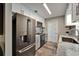 Bright kitchen with stainless steel refrigerator, white and grey cabinets, and granite countertops at 402 Merlin Ct, Brandon, FL 33510
