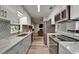 Modern kitchen features white and grey cabinets, stainless steel appliances, and granite countertops at 402 Merlin Ct, Brandon, FL 33510