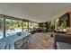 Enclosed lanai overlooking pool area, complete with brick flooring, seating area and outdoor dining set for seamless indoor/outdoor living at 402 Merlin Ct, Brandon, FL 33510