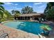 A backyard pool with well-maintained landscaping, a serene atmosphere and a screened-in lanai for outdoor relaxation and entertainment at 402 Merlin Ct, Brandon, FL 33510