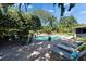 Inviting backyard pool with lush landscaping, brick patio, and comfortable lounge chairs for relaxation and enjoyment at 402 Merlin Ct, Brandon, FL 33510