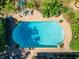 Aerial shot showcases a sparkling blue swimming pool with an inviting brick patio and poolside lounge area at 402 Merlin Ct, Brandon, FL 33510