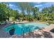 Backyard oasis featuring a private swimming pool, mature trees, and comfortable lounge seating for relaxation and entertainment at 402 Merlin Ct, Brandon, FL 33510
