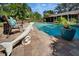A beautiful backyard pool area with a dolphin statue, potted plants, lush landscaping and comfortable lounge chairs at 402 Merlin Ct, Brandon, FL 33510