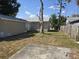 A view of the home's backyard featuring a concrete patio, grass, and a tree at 4420 6Th S Ave, St Petersburg, FL 33711