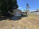 View of the backyard featuring a detached garage, a weathered fence, and a mature tree at 4420 6Th S Ave, St Petersburg, FL 33711