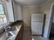Kitchen featuring stone countertops, stainless steel sink, white upper cabinets, and tiled floor at 4420 6Th S Ave, St Petersburg, FL 33711