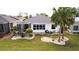 Landscaped backyard with a screened-in lanai, lush lawn, and decorative stone features offering serene outdoor living at 443 Noble Faire Dr, Sun City Center, FL 33573