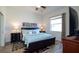 Cozy bedroom featuring a queen-size bed, dark wood furniture, and decorative artwork at 443 Noble Faire Dr, Sun City Center, FL 33573
