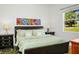 Bright bedroom featuring a bed, dark wood furniture, and colorful artwork at 443 Noble Faire Dr, Sun City Center, FL 33573