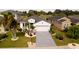 Aerial view of a home showcasing a well-manicured lawn, complemented by decorative landscaping and an extended driveway at 443 Noble Faire Dr, Sun City Center, FL 33573