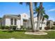 Charming home with lush landscaping, a well-manicured lawn, and a two-car garage with mature trees in front at 443 Noble Faire Dr, Sun City Center, FL 33573
