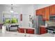 Bright kitchen with a stainless steel refrigerator, ample cabinet space, and a view of the backyard at 443 Noble Faire Dr, Sun City Center, FL 33573
