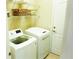 Functional laundry room equipped with a washer, dryer, and storage shelves at 443 Noble Faire Dr, Sun City Center, FL 33573