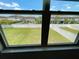 View of a well-maintained backyard with a green lawn and a white fence, seen through a large window at 4456 Globe Thistle Dr, Tampa, FL 33619