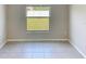 Bright bedroom featuring tile flooring, a window overlooking the lawn, and neutral-colored walls at 4456 Globe Thistle Dr, Tampa, FL 33619