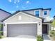 Exterior of a well-maintained two story home with a two-car garage and landscaped yard at 4456 Globe Thistle Dr, Tampa, FL 33619
