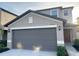 Two-story home showcasing a gray garage door with an entrance on the right, under a partly cloudy sky at 4456 Globe Thistle Dr, Tampa, FL 33619
