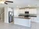 Kitchen featuring white cabinets, stainless steel appliances, an island and tile floors at 4456 Globe Thistle Dr, Tampa, FL 33619