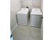 This is a laundry room featuring a washer and dryer and upper shelving at 4456 Globe Thistle Dr, Tampa, FL 33619