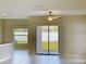 View of the living room displaying tile floors, ceiling fan, and a sliding door to the backyard at 4456 Globe Thistle Dr, Tampa, FL 33619